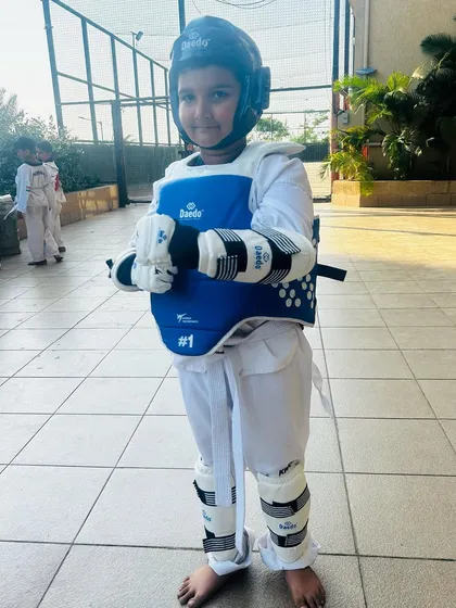 A young student fully geared up and ready for sparring practice.