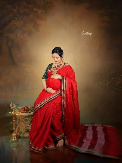 A quiet moment of anticipation captured in a beautiful red saree. The traditional props and painterly backdrop create a rich, artistic portrait that feels both personal and timeless.