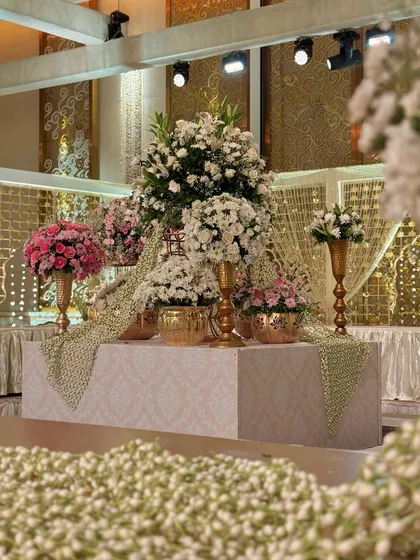 A beautiful floral installation with garlands of jasmine flowers. The combination of white and pink blooms against a golden backdrop is a timeless expression of elegance.