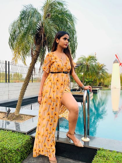 Styling for an upcoming music video. This breezy, sunflower-print maxi dress with a thigh-high slit creates a perfect resort-wear look for a poolside scene.