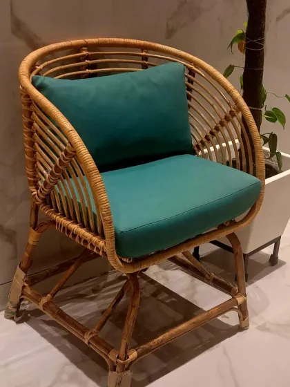 Our classic rattan armchair shown with a solid teal cushion. The sturdy base and gracefully curved back provide excellent support, making it a stylish and comfortable addition to any living room or reading nook.