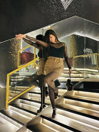 An artistic pose against the mirror, creating a beautiful reflection and highlighting the silhouette of the outfit.