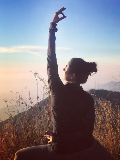 A close-up of a warrior pose during a mountain sunset. The focus here is on the alignment and the mudra, a quiet moment of intention as the day ends and the sky puts on a spectacular show.
