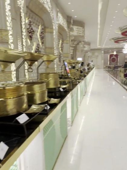 A panoramic view of a grand buffet line featuring gleaming brass serving dishes. This setup showcases the sheer scale and variety of the main course spread I offer.