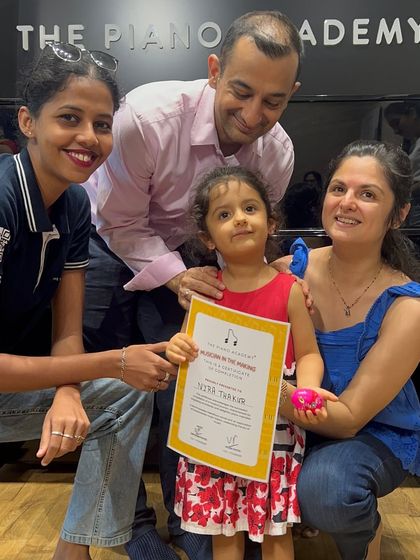 A family celebrates their little one's achievement at our summer camp certificate ceremony. Our programs are designed to be a joyful experience for both students and their parents.