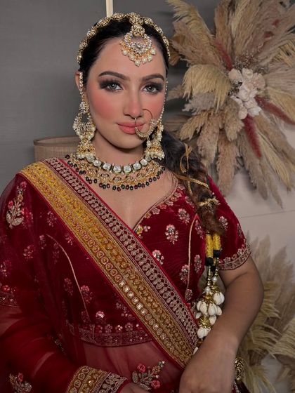 A classic red bridal look with a modern twist. The braided hair and soft glam makeup create a fresh and youthful appearance for the contemporary bride.