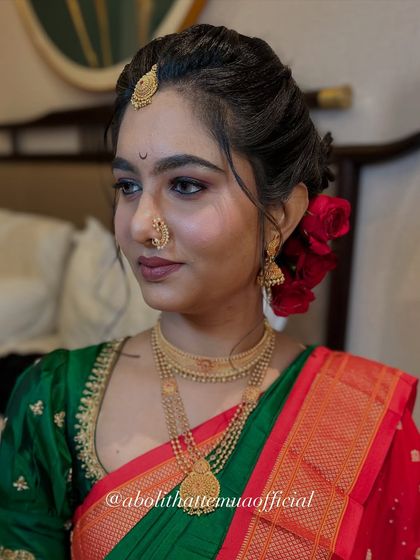 A beautiful portrait of bride Isha. Her makeup features defined brows, soft smokey eyes, and a classic red bindi, embodying the grace of a Maharashtrian bride.