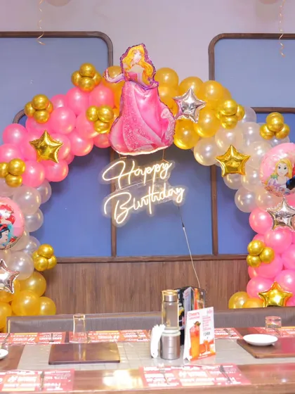 A close-up of the princess-themed balloon arch over the birthday table.
