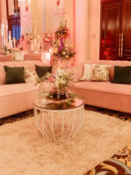 Comfort and elegance were key for this ring ceremony lounge. I chose plush, curved sofas in a soft blush pink, accented with floral and dark green cushions for a sophisticated and inviting space.