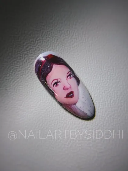 A hand-painted portrait of Disney's Snow White on a single nail, capturing her classic look.