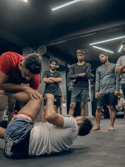 I demonstrate a leg lock submission while students observe, breaking down the technique step by step.