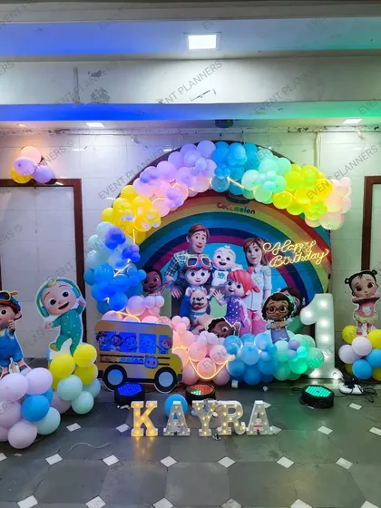 A wide view of the Cocomelon rainbow-themed birthday setup.