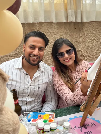 A couple enjoying the painting activity at a friend's baby shower. It's a relaxed and social activity that everyone can participate in.