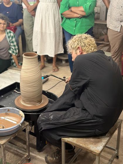 Kazuya Ishida using a blowtorch to dry the surface of a large vase on the wheel, a technique that allows him to build taller forms.