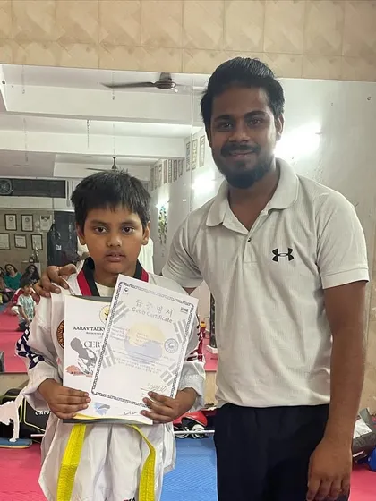 A student receiving his belt promotion test certificate. This official document marks his successful advancement to the next level in his Taekwondo training.