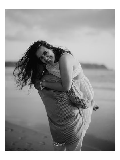 A happy and carefree piggyback ride on the beach, this black and white photo is full of life and laughter.