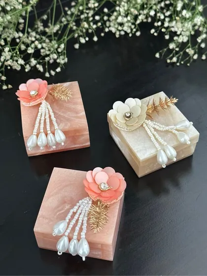 These small resin boxes with delicate floral and pearl tassels are a popular choice for custom hampers and favours. They add a touch of modern elegance to any gift.