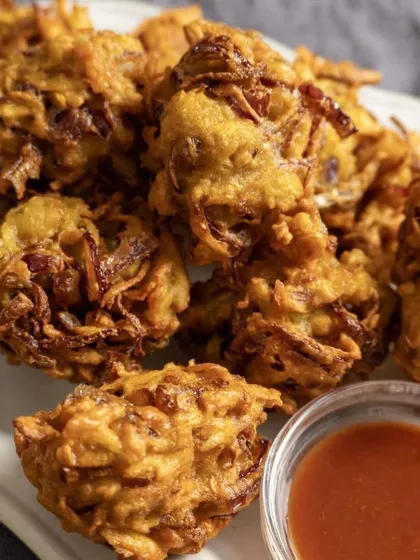A plate of our crispy Aloo Kanda Bhajiya (onion and potato fritters). They are the perfect crunchy and savory snack, especially when paired with a hot cup of tea.
