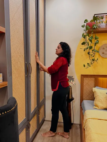 A shot of me interacting with a rattan wardrobe, showcasing its texture and design.