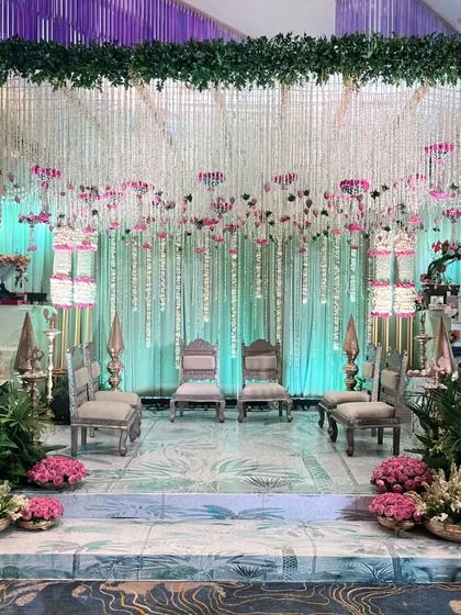 Another view of the stunning engagement stage, showcasing the intricate floral work and the elegant silver seating. The entire setup is designed to feel like a royal garden.