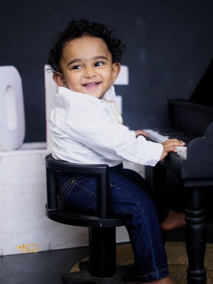 The birthday boy playing a miniature piano. These interactive props help bring out the most natural smiles and expressions.
