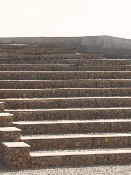 An entrance tunnel is built into the amphitheatre seating, providing access to the stage area. The entire structure is designed to be functional and durable, using materials that will weather naturally over time.