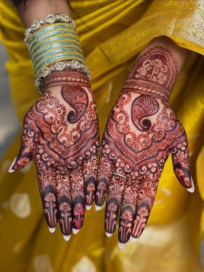 Both palms together, showcasing the beautiful, deep color of the engagement mehendi.