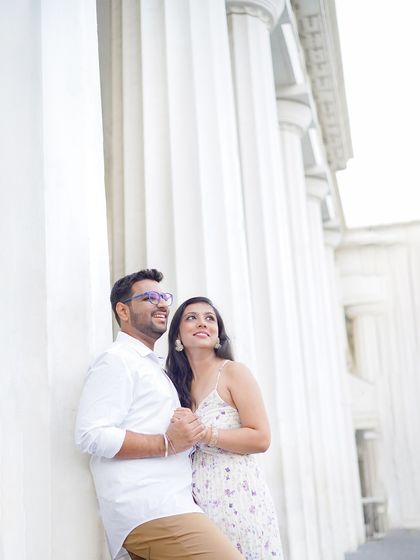A couple posing against grand, white pillars, creating a look of classic elegance. I use architectural elements to frame my subjects and add a sense of scale.