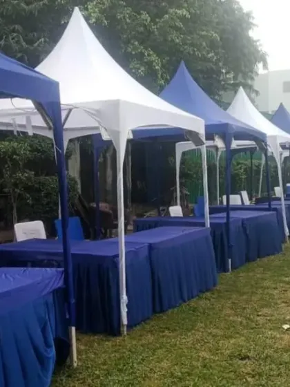 For exhibitions and trade shows, I can set up clean and professional stalls using pagoda tents or canopies. This setup in Greater Noida features a long row of stalls, each with its own table, ready for vendors.