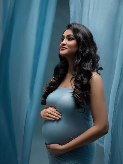 Looking towards the future. This profile shot in the blue gown captures a sense of hope and anticipation, with the soft fabric creating a beautiful frame.