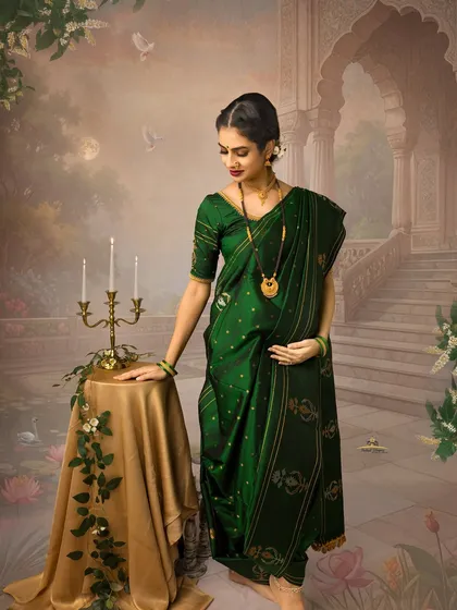 A solo portrait of the mother-to-be in a stunning green Navari saree. Her contemplative pose against the painterly backdrop creates a serene and timeless work of art.