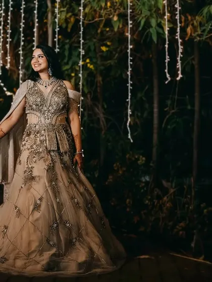 A romantic walk through a garden illuminated by hanging fairy lights. This shot captures the magical ambiance of a nighttime wedding celebration.