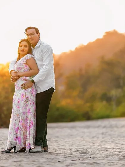 Bathed in the warm glow of the setting sun. This golden hour portrait by the river is incredibly romantic, highlighting the couple's embrace against a beautifully lit natural background.