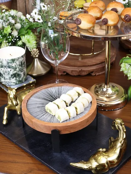 A Moon Ray stand styled on a black marble platter, surrounded by our golden horse figurines. This composition highlights how our different collections can be mixed and matched for a unique look.