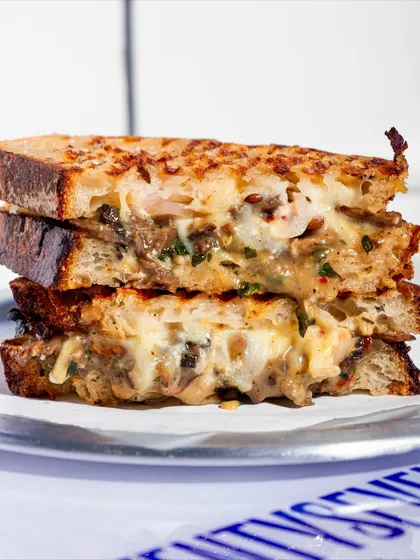 A stacked view of the Cheesy Mushroom Melt, showing the generous filling and the perfectly toasted sourdough. It's a hearty and delicious meal.