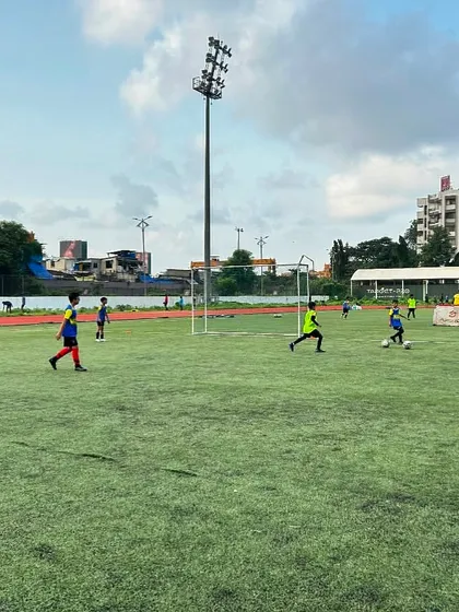 A wide view of a training session on the pitch, with players participating in various drills. This image represents the football field as a sanctuary where players focus solely on self-improvement.