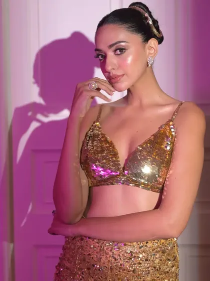 This shot shows the model interacting with the camera, with the sleek high bun providing a clean and sophisticated frame for her face.