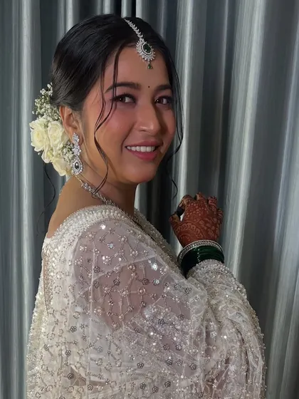 A side view showing the fresh floral arrangement in her hair, adding a touch of romance.