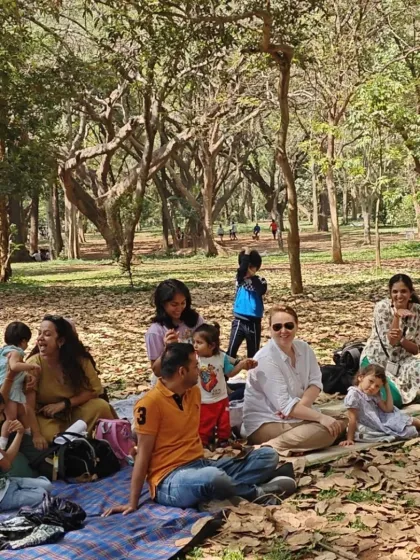 A happy gathering of families enjoying a picnic under the trees. Our events are perfect for creating a sense of community and shared joy.