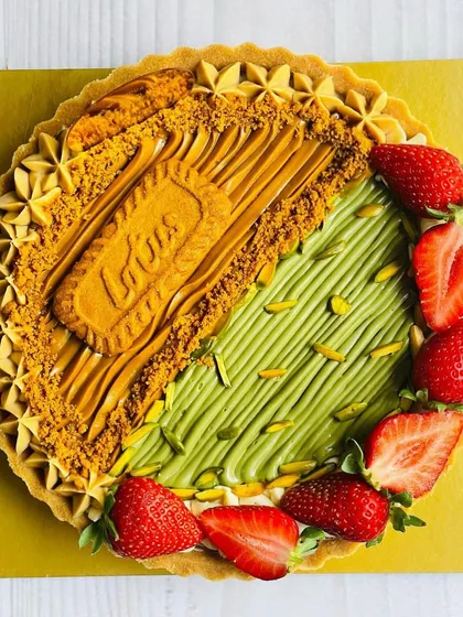 A delectable Half & Half Cheesecake Tart featuring a blend of Pistachio Cream and Strawberry on one side, and the irresistible crunch of Lotus Biscoff on the other.