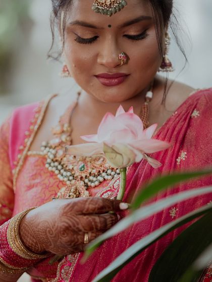 A portrait of a bride holding a lotus flower, symbolizing her grace and the beauty of new beginnings.