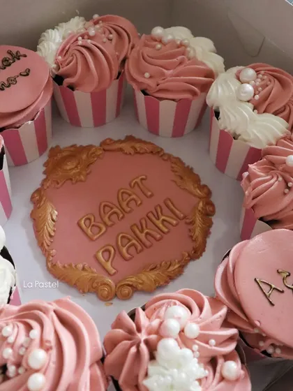 A closer look at my 'Baat Pakki' cupcake platter. I surround a custom-made plaque with delicious cupcakes in your chosen colors, some with personalized messages like 'Mubarak Ho'.