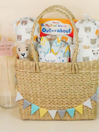 A baby gift basket filled with books, toys, and blankets. This shot showcases a hamper packed with a wide variety of items.