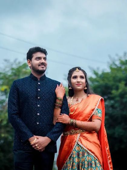 A classic portrait of an engaged couple, standing together in a beautiful outdoor setting.