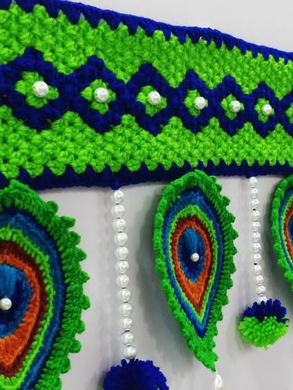 An angled view of the Mor Pankh toran hanging, which shows how the feathers drape beautifully.