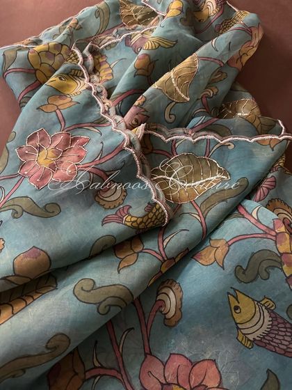 The dupatta is draped to showcase its delicate, scalloped edging, which provides a refined finish to the ethereal organza fabric.