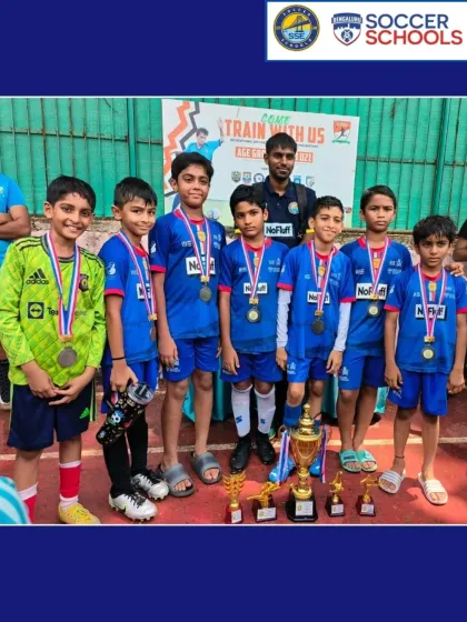 A young team with their medals and trophies after a successful pre-season tournament. Early exposure to competitive football is key.