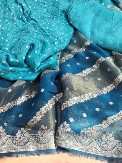 A beautiful Banarasi Bandhej suit material in shades of teal. The set combines the traditional tie-dye of Bandhej with the rich weave of Banarasi silk for a truly festive outfit.