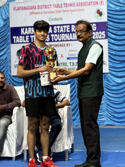K J Aakash receiving his Men's Singles Winner trophy at the state ranking tournament in Hospet.