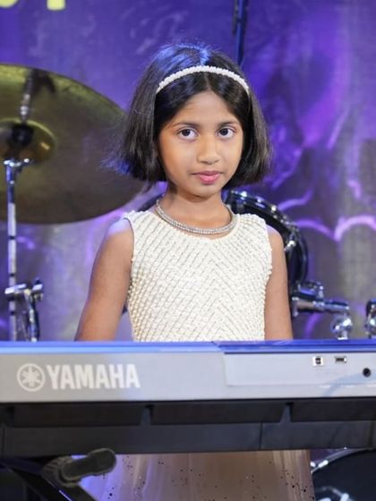 A young girl confidently playing her part in the keyboard ensemble.